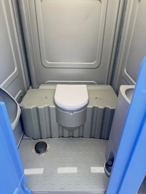 Seat inside a gray portable toilet