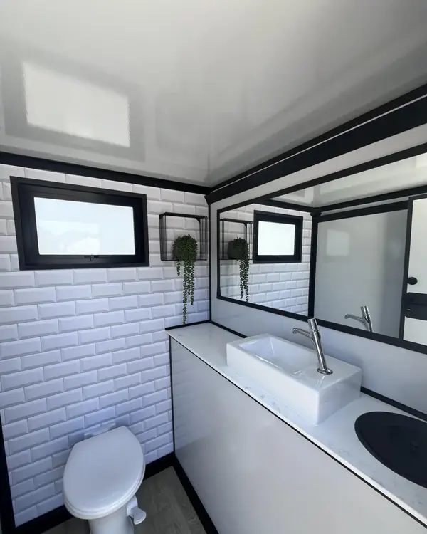 Restroom trailer room with white tile walls and toilet