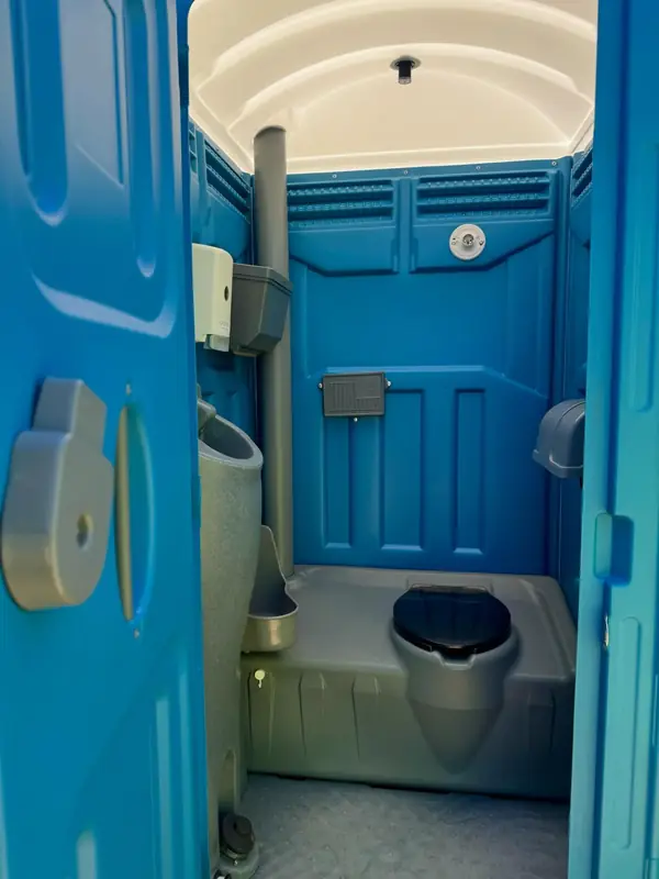 Blue standard porta potty interior with urinal and seat